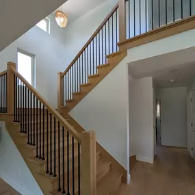 This newly renovated home by Balbes Custom Builders features a beautiful pine staircase with lovely custom bannister. Golden hour gleams through the windows on the landing, helping this house show off its beauty.