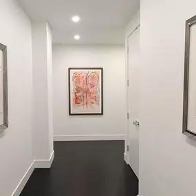 No detail is overlooked in this custom remodel by Balbes Custom Builders. Even a simple hallway has been transformed into a bespoke place to showcase the owner's art collection. With the bright contrast between the white walls and dark, dramatic flooring, it's a perfect way to show that details truly matter.