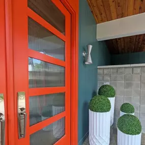 Bold and eye-catching, this warm pop of color brings whimsy and joy to this home addition by Balbes Custom Builders. Welcoming and unique, it hints at all the delightful details inside.
