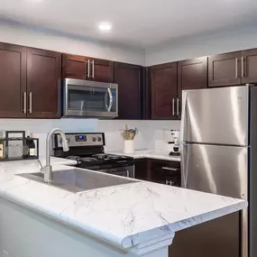 Modern style kitchen with espresso cabinets at Camden Reunion Park