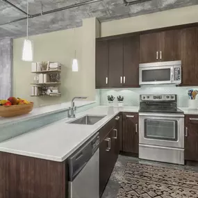 Kitchen with glass cooktop two tier quartz countertops and tile backsplash