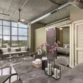 Open concept living and dining room with barn door to bedroom and concrete flooring