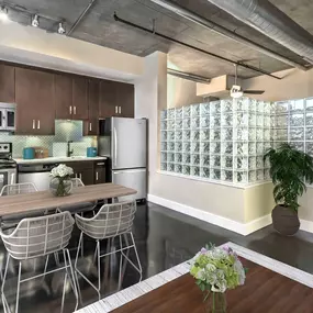 Open-concept studio floor plan with industrial-style living, dining, and kitchen area