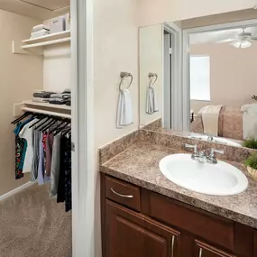 Bathroom and walk in closet with wood shelving