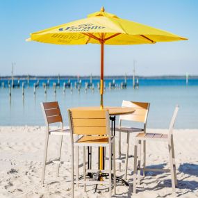 beach table and chairs under a yellow umbrella
