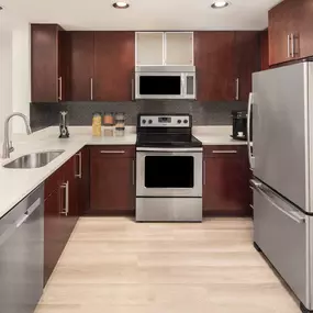 Warm modern style features an open-concept kitchen and dining space at Camden NoMa apartments in Washington, D.C.