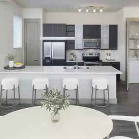 Dining area looking into a modern kitchen with a laundry closet at Camden Victory Park apartments in Dallas, TX