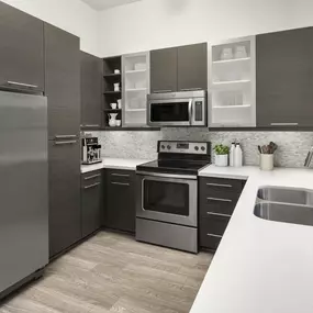 Kitchen with a wraparound white quartz countertop, modern cabinets, and stainless steel appliances at Camden Victory Park apartments in Dallas, TX