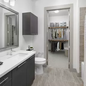 Bathroom with modern tile and white quartz countertops and attached closet at Camden Victory Park apartments in Dallas, TX