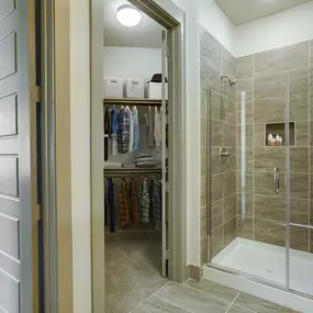 Bathroom with tiled walk-in shower and large walk-in closet at Camden Victory Park