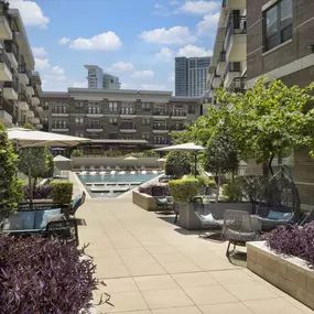 Poolside lounge with seating and umbrellas at Camden Victory Park apartments in Dallas, TX