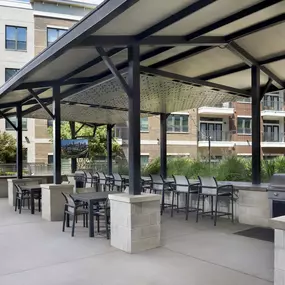 Covered outdoor lounge pavilion with grills, seating and TVs at Camden Victory Park apartments in Dallas, TX