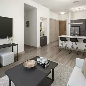 Living room and kitchen with entry nook and wood-style flooring at Camden Victory Park apartments in Dallas, TX