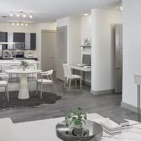 Open-concept living room, dining room, and kitchen with wood-style floors and nook workspace at Camden Victory Park apartments in Dallas, TX