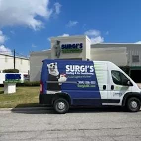 Surgi's Heating, Cooling & Plumbing work van near the building