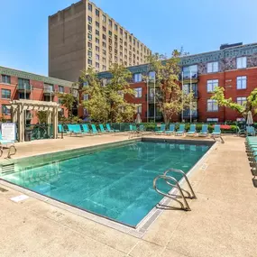 Swimming pool with chairs and a building in the background