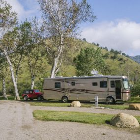 A photo of an RV with a trailer hitch on the campground