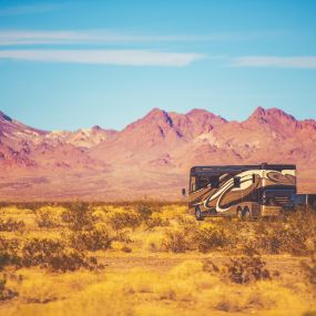 Camper trailer with hitch towing car through the desert