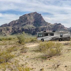 A photo of RV towing car with trailer hitch through the mountains