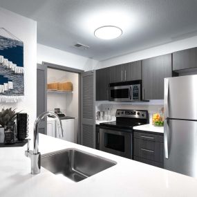Modern style kitchen with stainless steel appliances and white quartz countertops