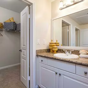 Traditional style bathroom with granite countertops and walk in closet