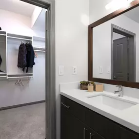 Modern style bathroom white quartz countertops and walk in closet with built in drawers and shelves