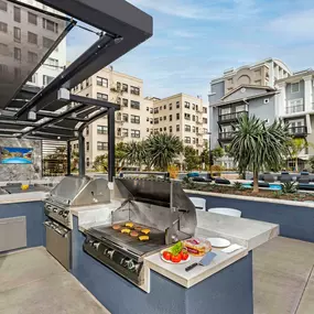 Barbecue grilling stations with bar stool seating near secondary pool and outdoor seating area