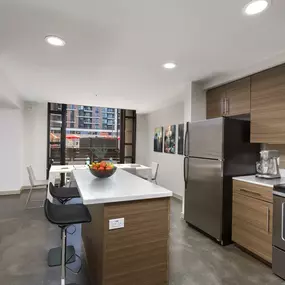 Live work kitchen with barstool seating white quartz countertops and stainless steel appliances