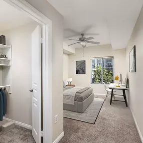 Traditional style bedroom with walk in closet and ceiling fan and space for a desk