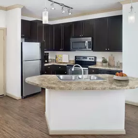 Apartment kitchen with island in Camden Town Square located in Kissimmee Florida