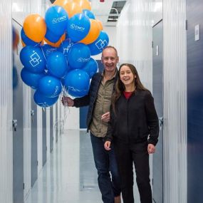Family walking down storage corridor with balloons - Cinch Self Storage