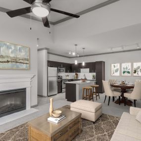 Open concept kitchen. dining and living room at Camden Asbury Village in Raleigh, NC.  The kitchen features stainless steel appliances, a dining area with a table set for four people and the living room featuring an electric fireplace.