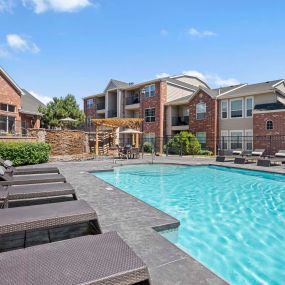 Resort-style pool with lounge chairs and a water feature at Camden Caley in Englewood, CO