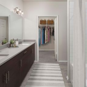 Double sink vanity with gray quartz countertops and walk-in closet attached at Camden Caley in Englewood, CO