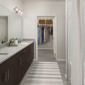 Double sink vanity with gray quartz countertops and walk-in closet attached at Camden Caley in Englewood, CO