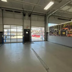 Jeff Wyler Chrysler Dodge Jeep Ram of Fort Thomas Service Department showcased in this photo, providing a view from inside the garage with doors designed like windows and one marked Entrance, Sound Horn, highlighting organized vehicle access and efficient service operations.