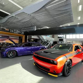 Jeff Wyler Chrysler Dodge Jeep Ram of Fort Thomas showroom showcased in this photo, featuring new Dodge performance cars on display and highlighting a modern, welcoming dealership environment for drivers near Northern Kentucky and Cincinnati.