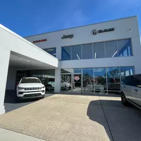 eff Wyler Chrysler Dodge Jeep Ram of Fort Thomas main entrance showcased in this photo, featuring Dodge, Jeep, and Ram signage and vehicles on display outside, welcoming customers to explore a full selection of new and used cars, trucks, and SUVs in Northern Kentucky.