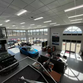 Jeff Wyler Chrysler Dodge Jeep Ram of Fort Thomas showroom showcased in this photo, featuring a spacious view from above with consultation desks where customers meet with sales and service representatives to explore new vehicles and financing options.