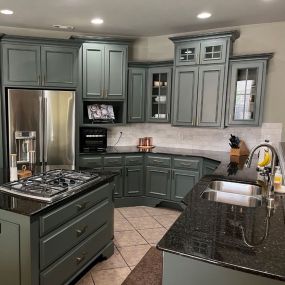 We love how these green cabinets complement the dark countertops. Our cabinet painting service is a cheaper way to completely change the vibe of your space.