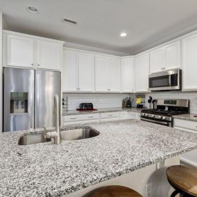 You can achieve a bright look in your kitchen with design elements like your cabinet color and countertops, not just with lighting! These beautiful countertops and white cabinets completely brighten the space!