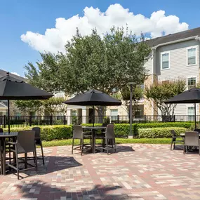 Resort- style pool with outdoor seating at Camden Downs at Cinco Ranch Apartments in Katy, TX.