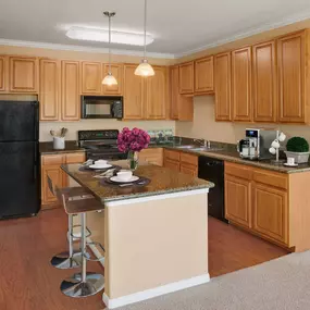 Kitchen with large island, granite countertops and black appliances