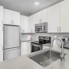 Kitchen with gray quartz countertops and white cabinets