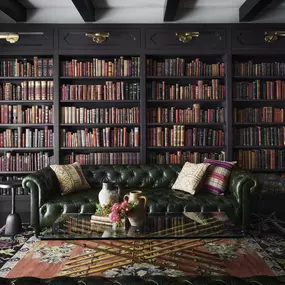 Library lined with bookshelves and green leather seating.
