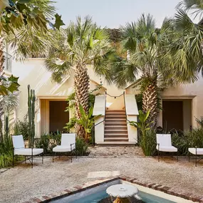 Courtyard with palm trees, fountain, and seating outside.