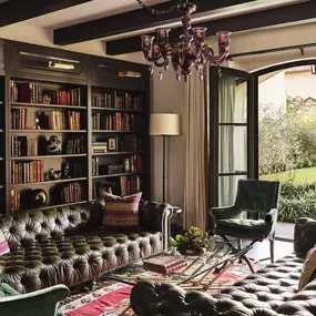 Cozy library-style suite with velvet chair, sofa and bookshelves.