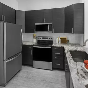 Kitchen with stainless steel appliances and granite countertops at Camden Dulles Station apartments in Herndon, VA