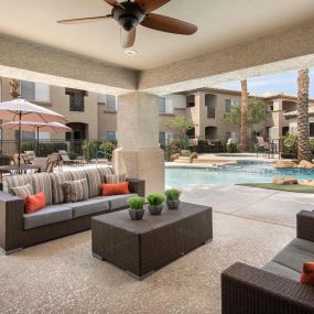Outdoor lounge with seating areas and ceiling fan