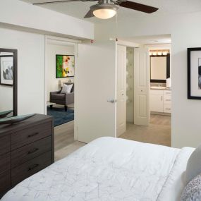 Bedroom with ensuite bathroom ceiling fan and carpet flooring